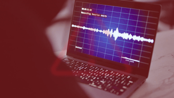 AI voice cloning waveform displayed on a laptop during a cybersecurity recording session.